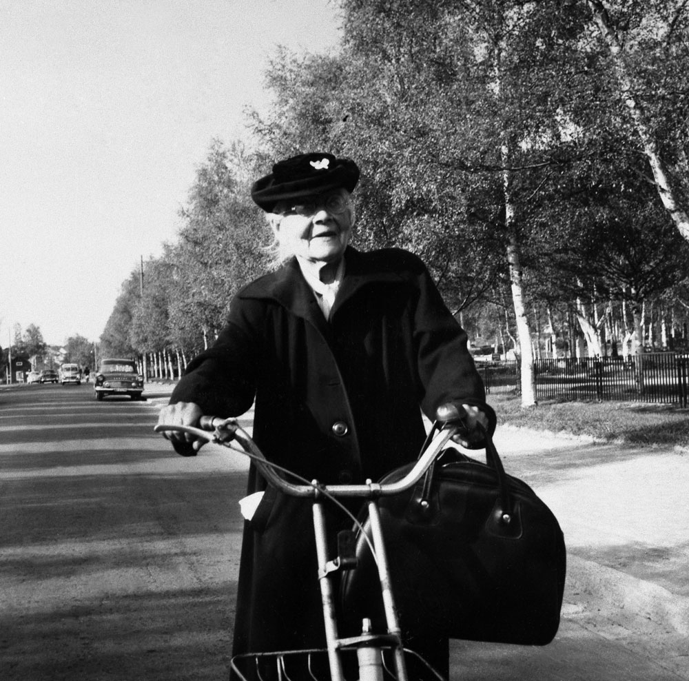 Äldre dam på sparkcykel.